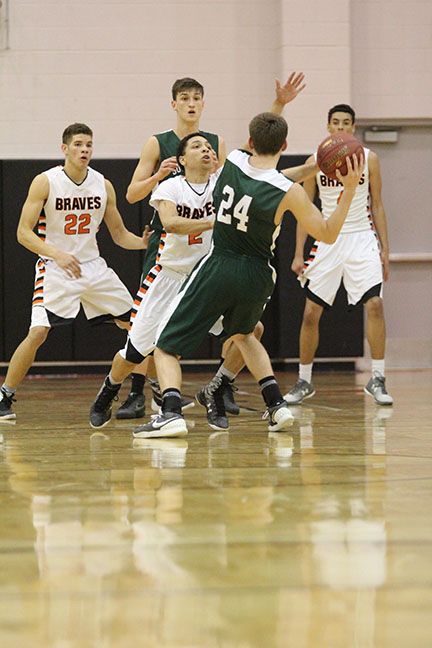 Junior guard Jadon Pouncil plays tight defense against a Timber Wolf guard in the photo above.
