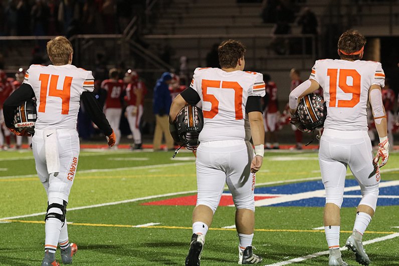 Captains Ethan Byers, Jacob Peterson, and Bryce Krone take the field against Miege.