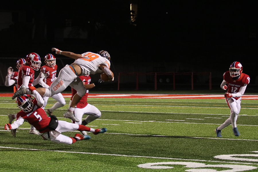 Running back Bryce Krone hurdles over Meige defenders in the 57- 16 loss.