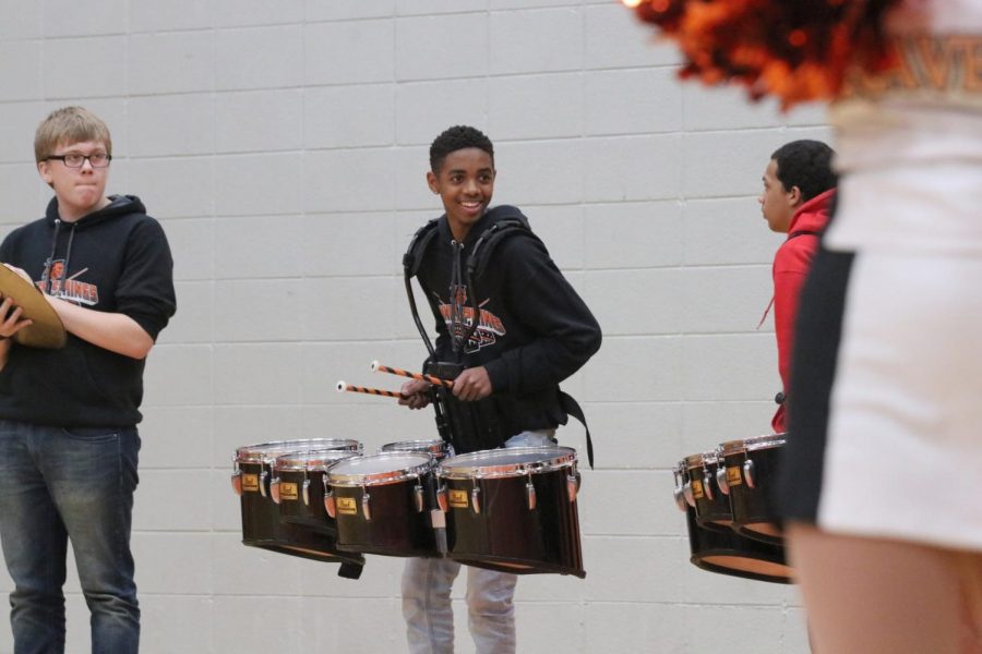 Drumming with glee, junior Christian Doss smiles as he plays the snare. 