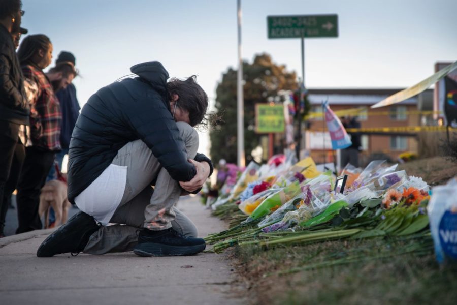 A Person mourning over the memorials set out for the victims. 