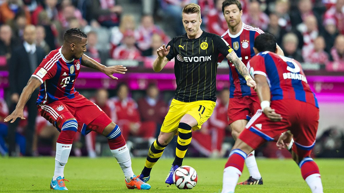 MUNICH, GERMANY - NOVEMBER 01: Marco Reus is challenged by Jerome Boateng (Bayern) and Mehdi Benatia (Bayern) during the Bundesliga match between Borussia Dortmund and FC Bayern Muenchen at Allianz Arena on November 1, 2014 in Munich, Germany. (Photo by Alexandre Simoes/Borussia Dortmund/Getty Images)