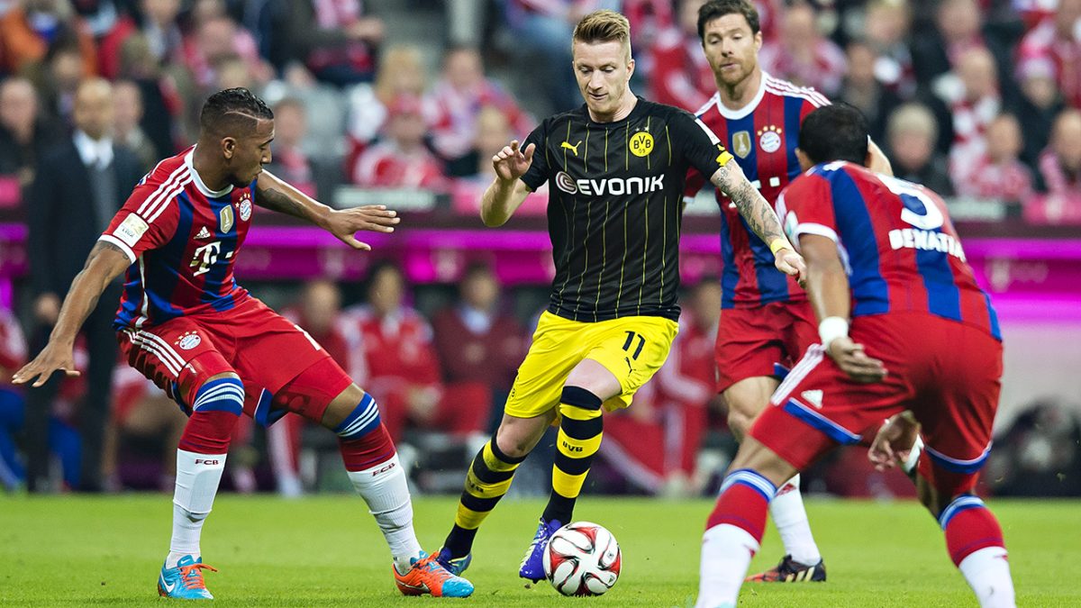 MUNICH, GERMANY - NOVEMBER 01:  Marco Reus is challenged by Jerome Boateng (Bayern) and Mehdi Benatia (Bayern) during the Bundesliga match between Borussia Dortmund and FC Bayern Muenchen at Allianz Arena on November 1, 2014 in Munich, Germany.  (Photo by Alexandre Simoes/Borussia Dortmund/Getty Images)